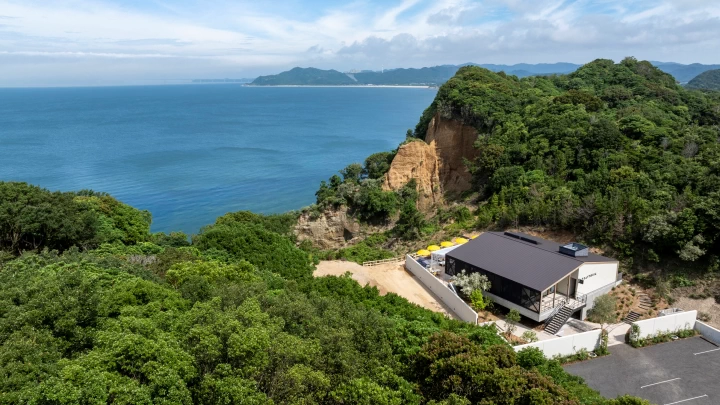 真っ青な海と白砂が煌めくビーチを望む崖の上の一軒家レストラン